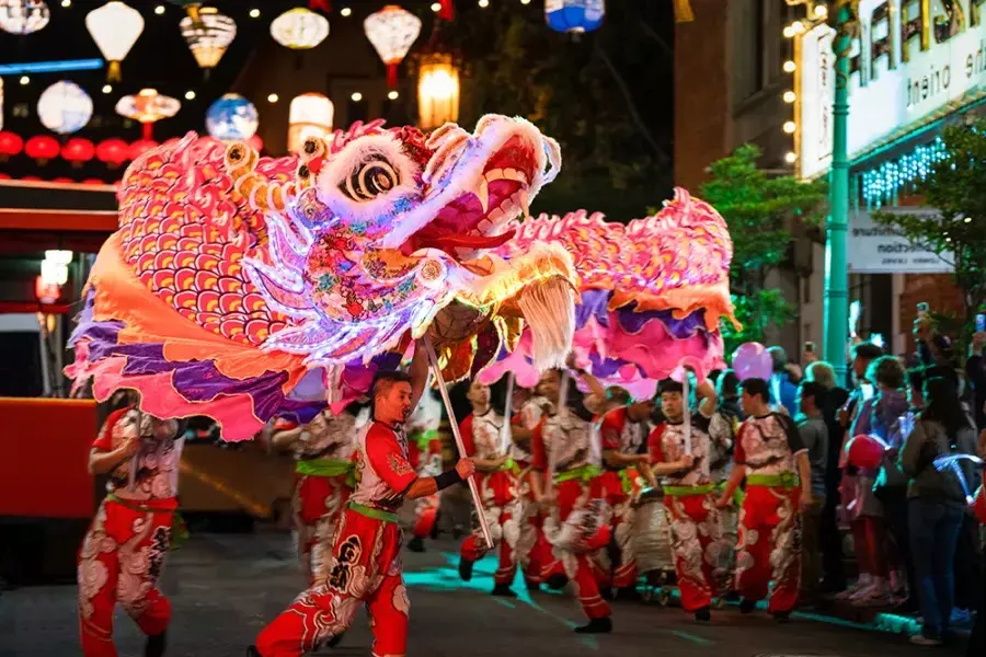 舞者在威尼斯人官网平台app农历新年游行中操纵一个巨大的物体, beleuchteten Drachen.